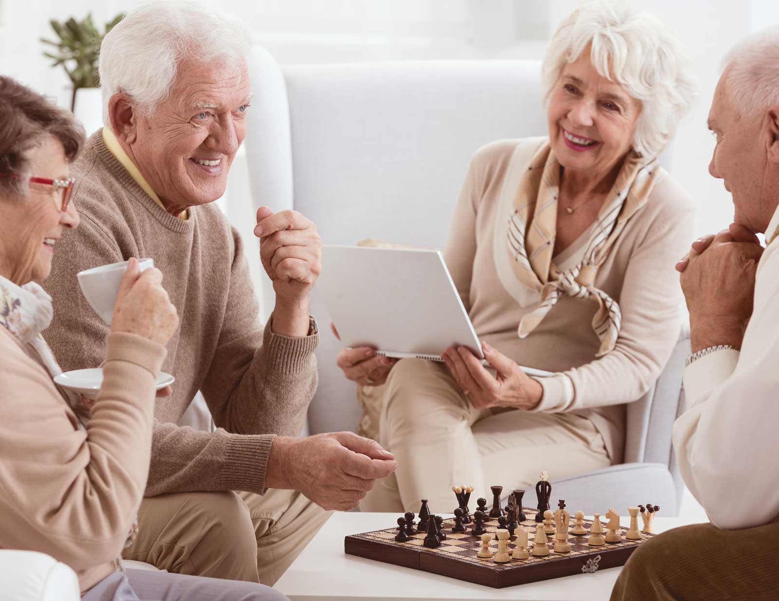 older couples playing chess and drinking coffee